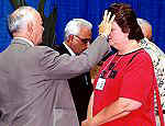 The Rev. Aldo Martin (left), superintendent of the Lakeland District, anoints a delegate.